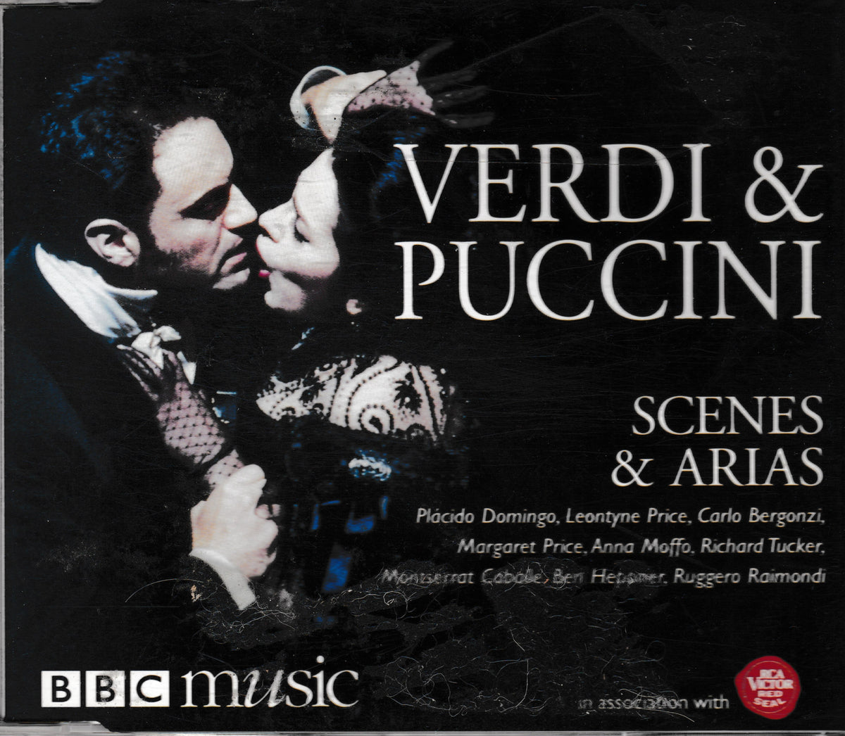 Album cover for 'Verdi & Puccini Scenes & Arias' on BBC Music, featuring a dramatic black-and-white photo of a man and woman embracing, with large white title text and cast names on a dark background.
