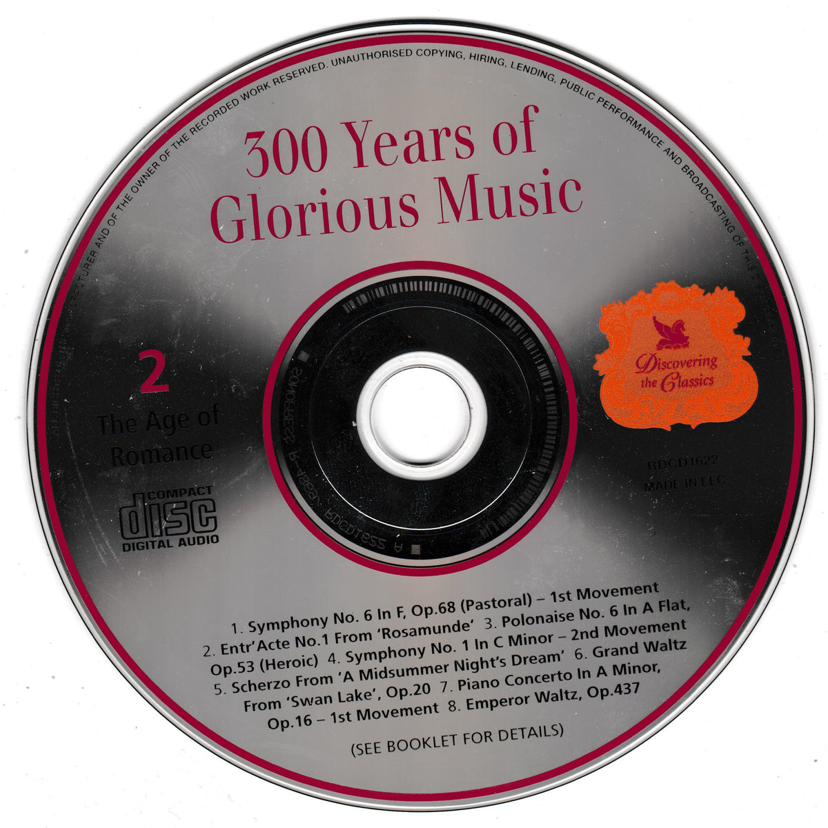 A compact disc with printed tracklist and title text reading '500 Years of Glorious Music,' plus a bright orange logo and small 'Discovering the Classics' text, photographed on a plain light background.