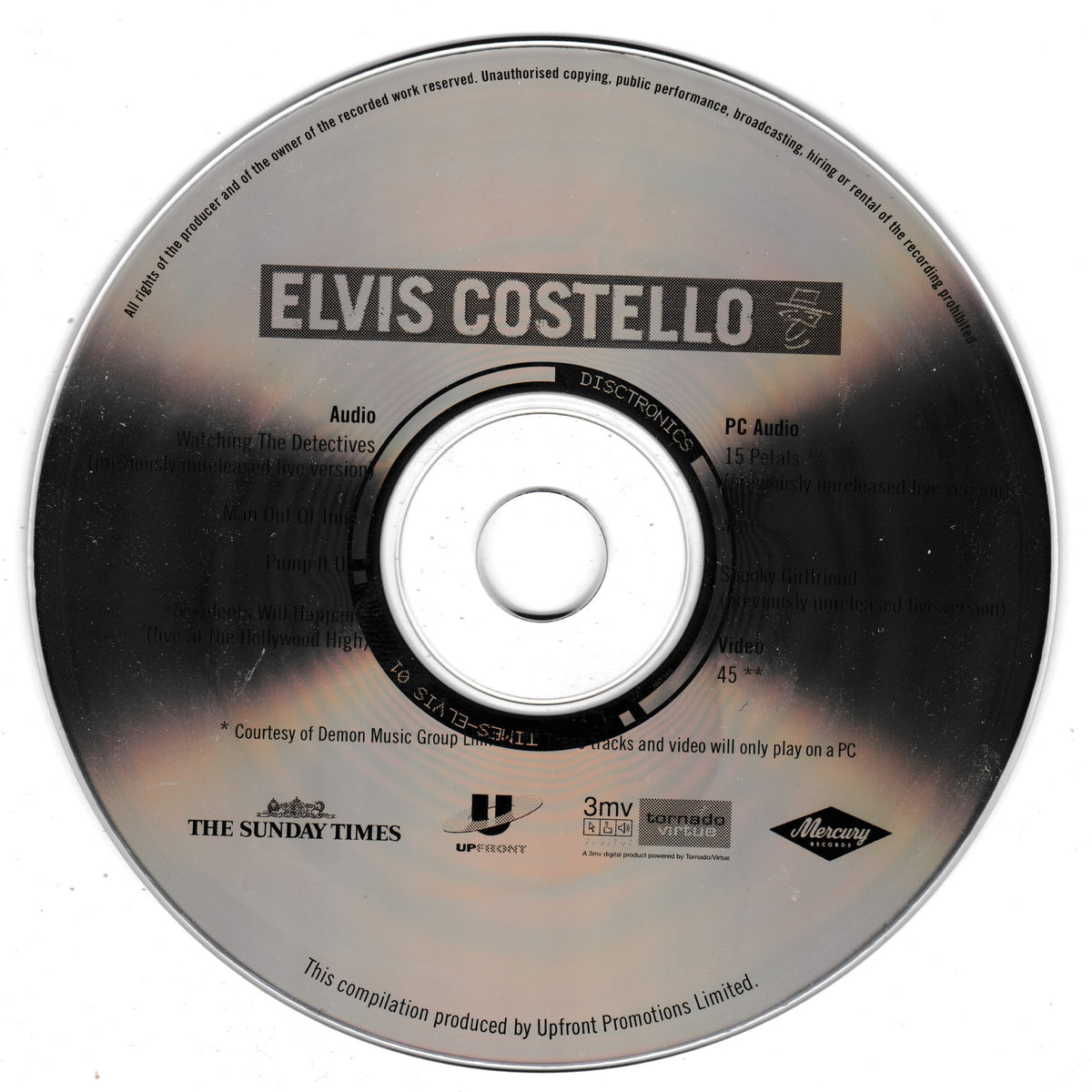 A vintage CD for Elvis Costello's compilation album, featuring a silver reflective disc with black text and logos.