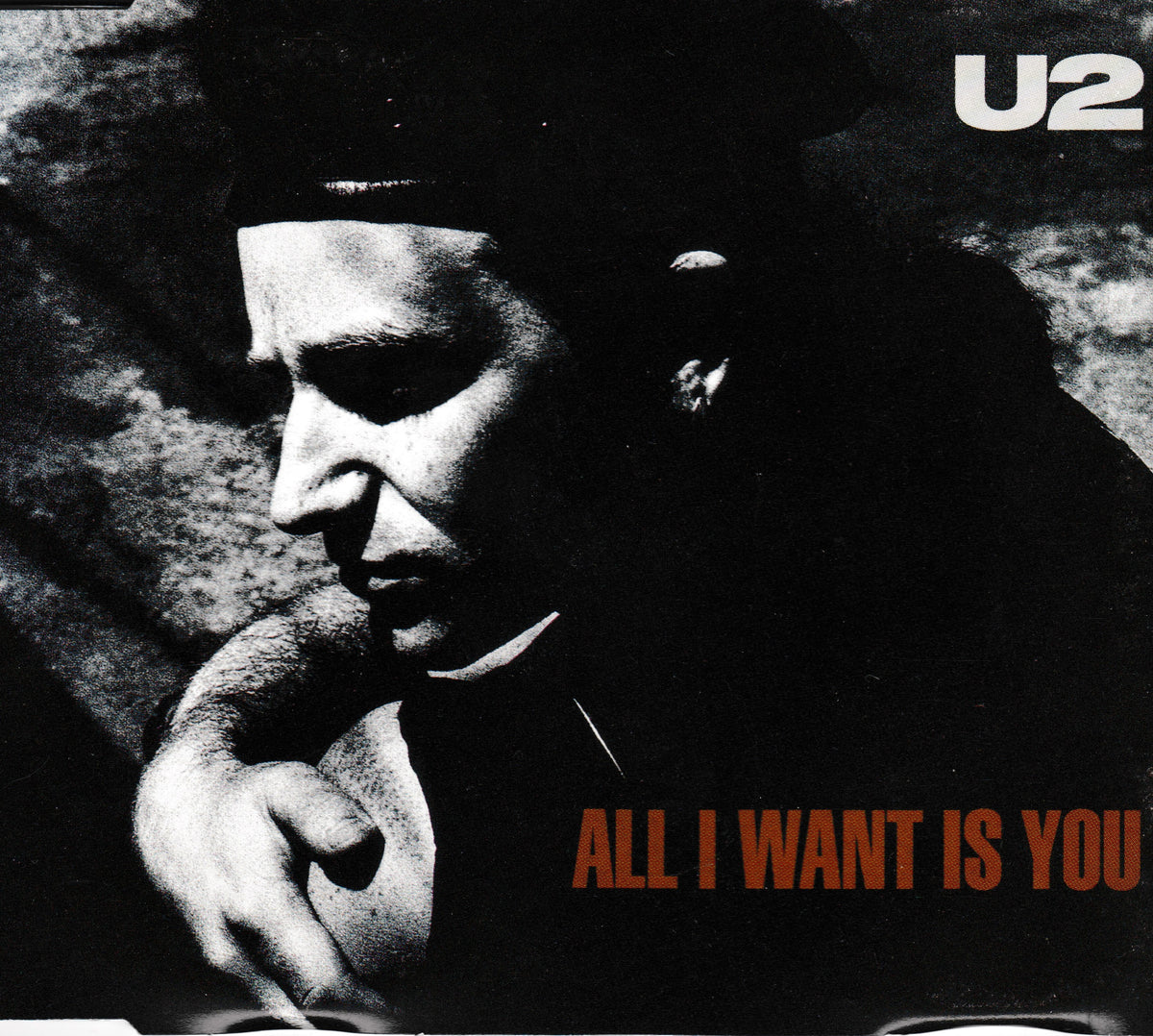 U2 'All I Want Is You' CD single cover featuring a high-contrast black and white portrait of Bono, with the band name 'U2' in white at the top right and the album title in orange-red at the bottom right.