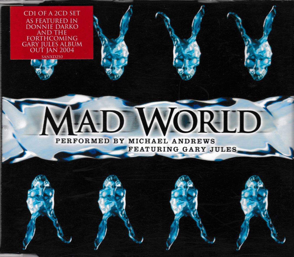 CD cover for 'Mad World' performed by Michael Andrews and featuring Gary Jules, with a black background, blue crystalline frog-like figures, and a red notice in the top left corner.