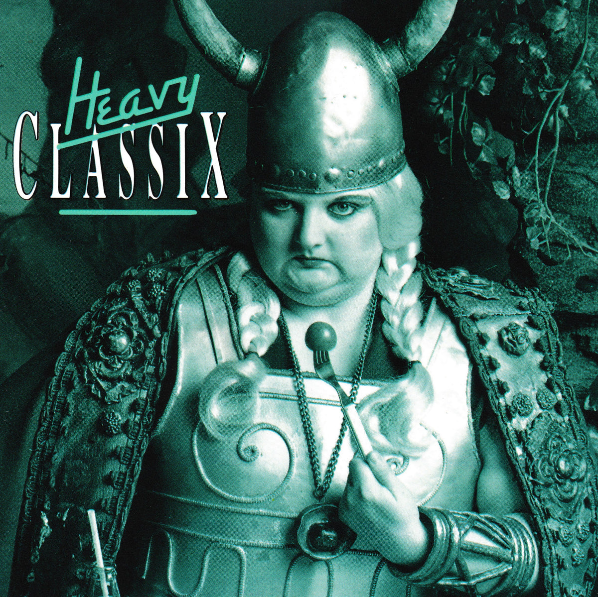 Album cover art for 'Heavy Classix' featuring a stylized, monochrome green-toned image of a person in Viking-style armor with a horned helmet, ornate shoulder pieces, and braided hair, with the title text 'Heavy Classix' in the upper left.