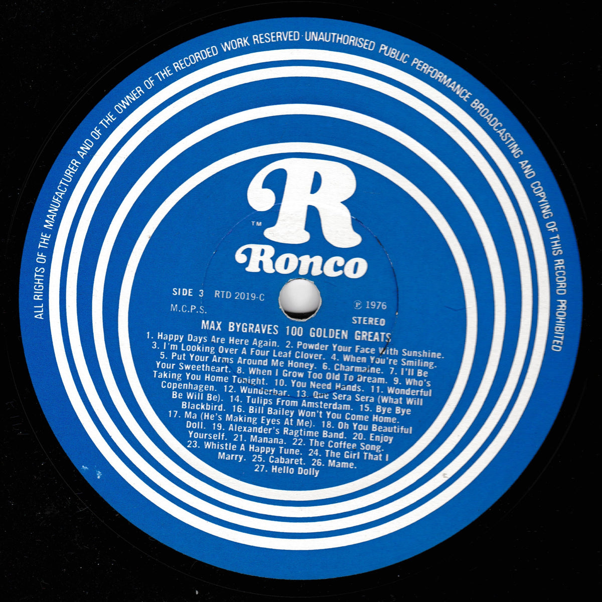 A close-up of a blue and white Ronco vinyl record label with the tracklist for Max Bygrave's 100 Golden Greets.