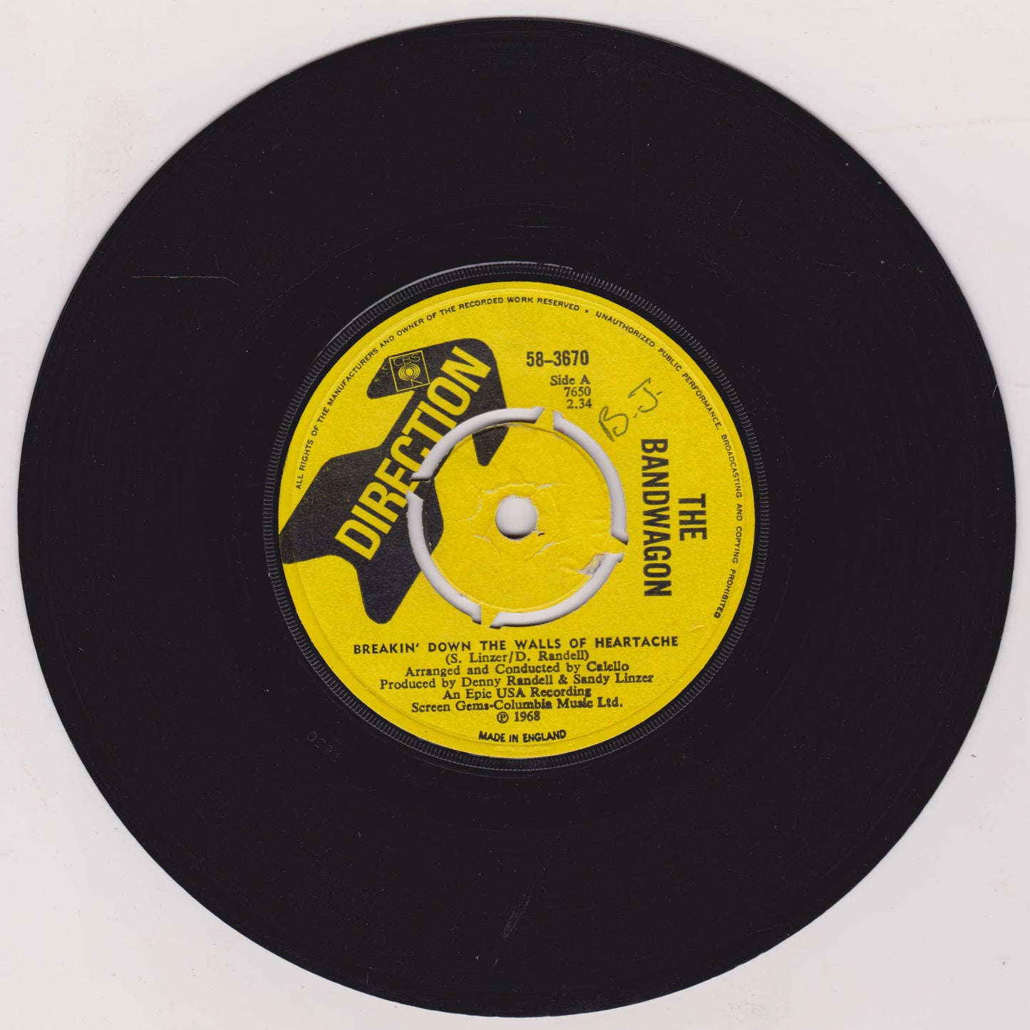Black vinyl record with a yellow label featuring text and graphics on a white background
