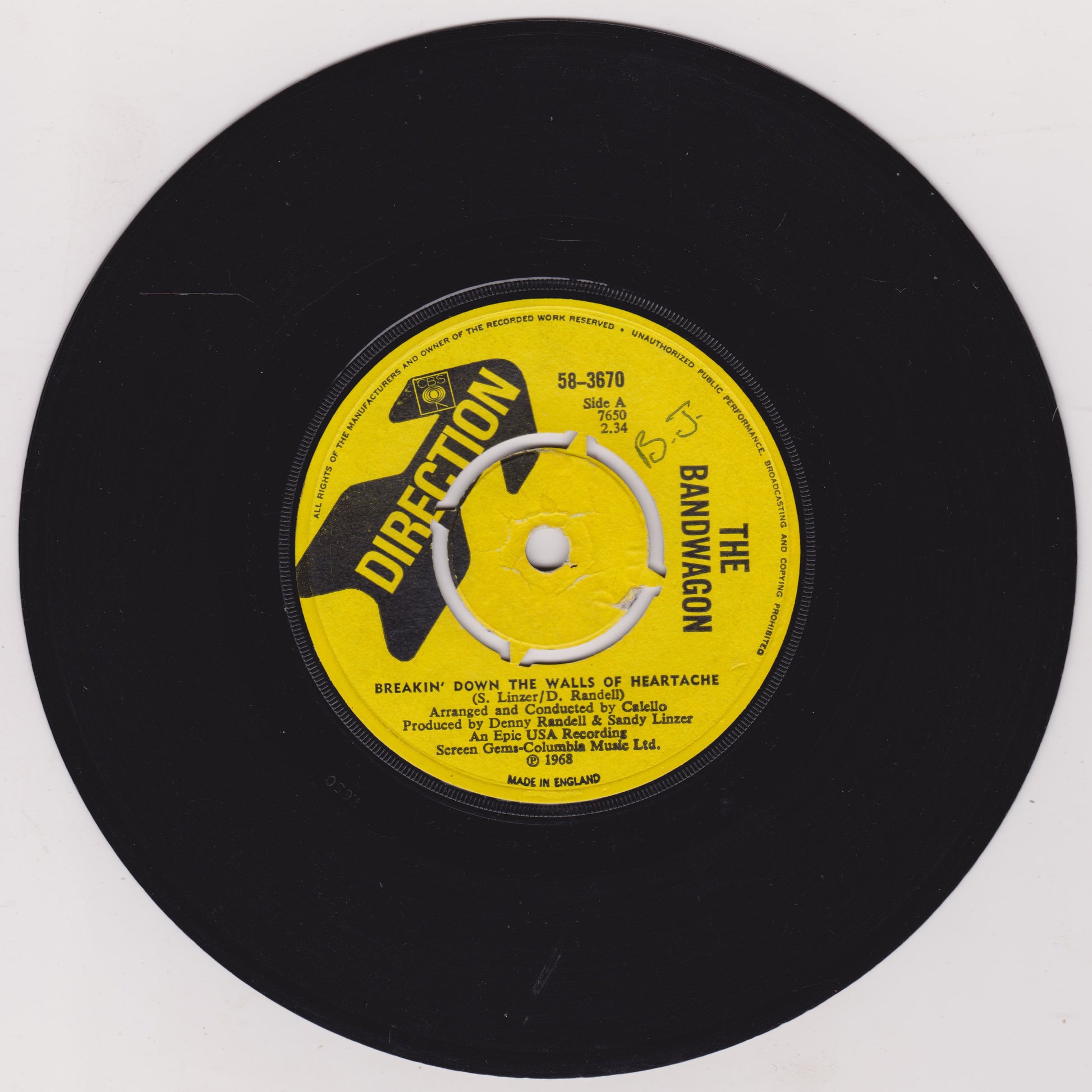 Black vinyl record with a yellow label featuring text and graphics on a white background