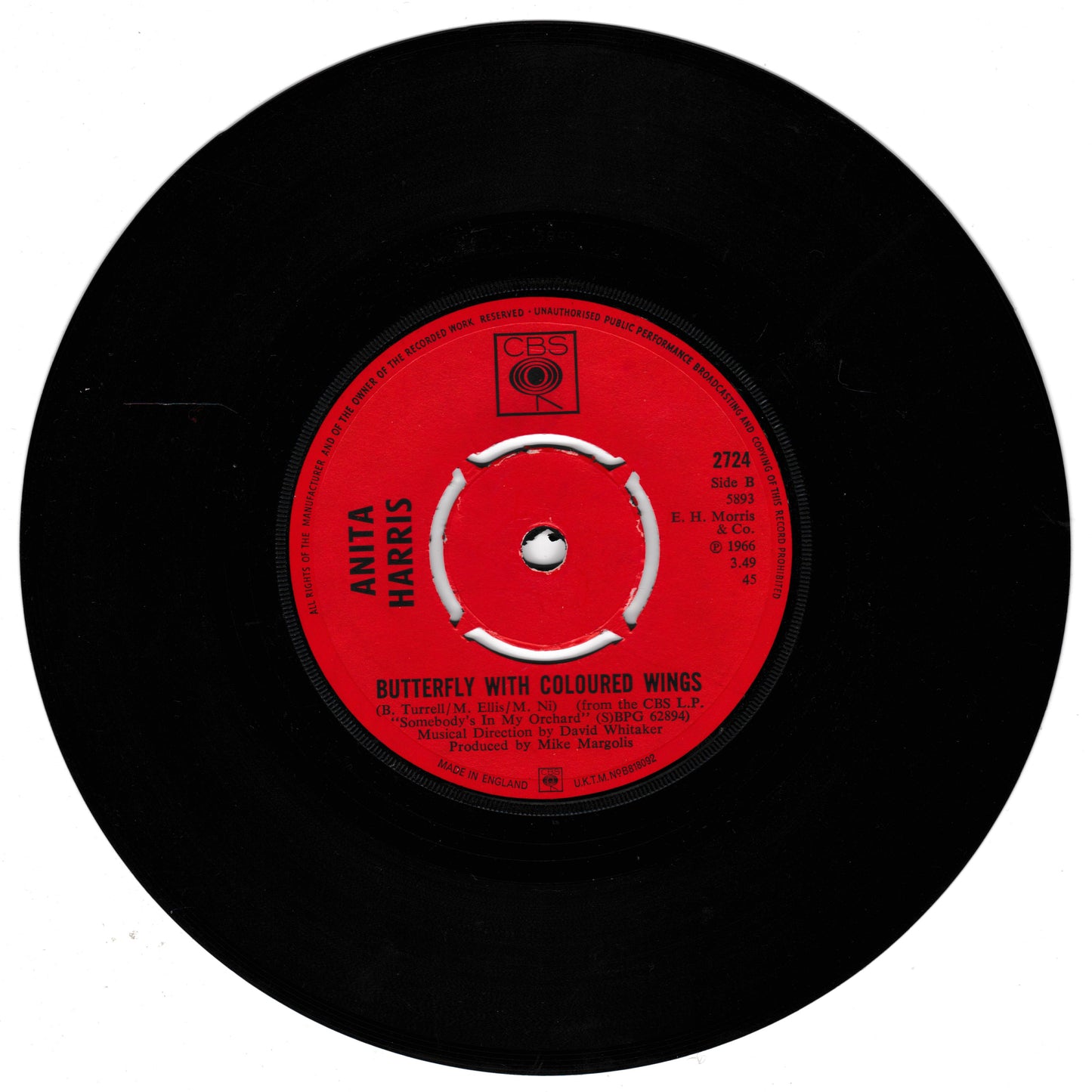 Black vinyl record with a red label featuring text and a logo.