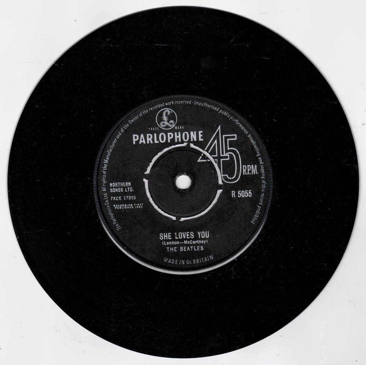 A black 45 RPM vinyl record with a white Parlophone label, featuring The Beatles' song 'She Loves You'.